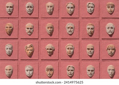 Facade to the triangular Teatre Square of the 1950 opened, 2016 reconstructed, Teatri Andon Zako Cajupi featuring the masks of Comedy and Tragedy and 160 smaller masks as the audience. Korce-Albania.