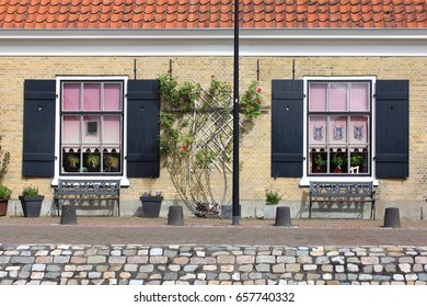 A facade with two Windows, and benches