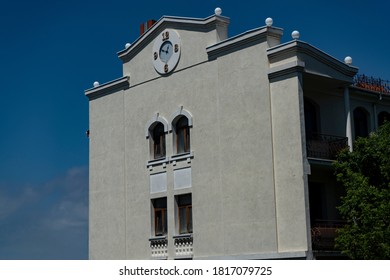 The facade of a two-story building with a round clock.