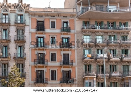 Facade of a typical apartment building in Barcelona, Spain. Exterior building with balconies and window shutters