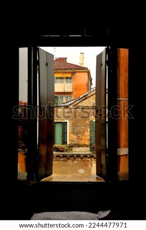 The facade of a typical exposed brick house in Venice, Italy, is viewed from a hotel window.
