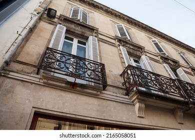 Facade of a typical old French residential building in Bordeaux, France, made of freestone, hosting flats, with a southwestern French architecture and some metal blinders.