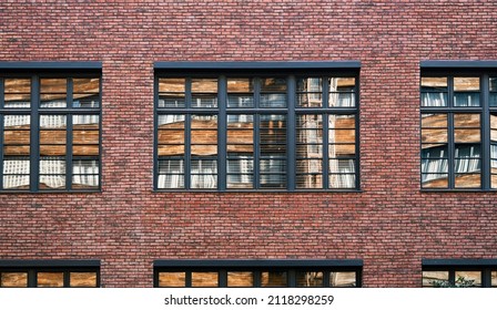 Facade Wall Of A Brick Building With Windows. The Opposite Wall Reflected In The Window Pane. Smooth Rows Of Old Masonry. Background Image, Screensaver