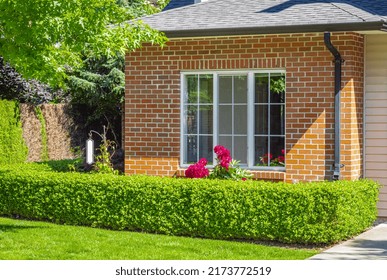 Facade With Window Of A Brick House With A Patio On A Bright Sunny Day In Vancouver Canada. Facade Of Residential Home. A House With Sunlit Exterior. House Front Door. Nobody-June 24,2022