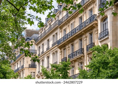 Facades of residential buildings in classic Parisian Haussmannien style built along a tree-lined avenue. Concept of residential real estate market for old housing in France and Paris - Powered by Shutterstock