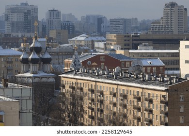 Facades, roofs, windows, silhouettes of new and old houses, as well as the domes of churches in one of the districts of Moscow on a winter day. - Shutterstock ID 2258129645