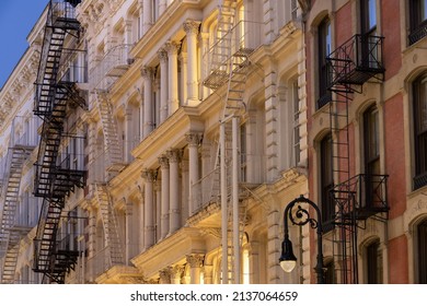 Facades Of Soho Loft Buildings With Fire Escapes At Dusk. Lower Manhattan, New York City