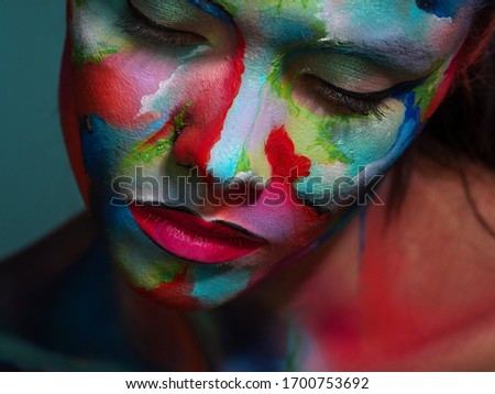 Face art and creative makeup, a young beautiful woman abstract art on the face, an unusual idea.