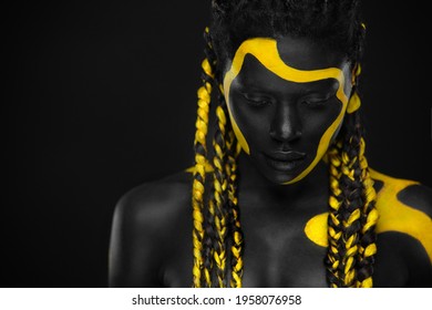 Face Art. Woman With Black And Yellow Body Paint. Young African Girl With Colorful Bodypaint. An Amazing Afro American Model With Yellow Makeup.