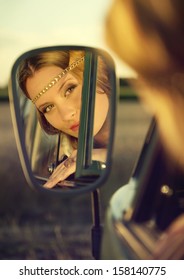 Face Of An Attractive Brunette Woman In The Rear Mirror Of An Old Car