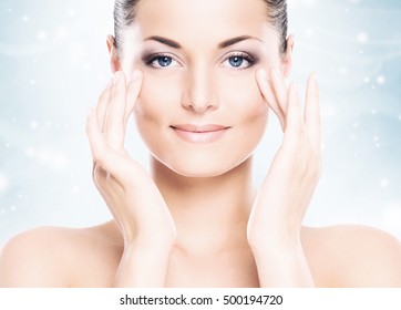 Face Of Attractive And Healthy Woman Over Seasonal Christmas Background With A Winter Snowflakes. Healthcare, Spa, Makeup And Face Lifting Concept. 