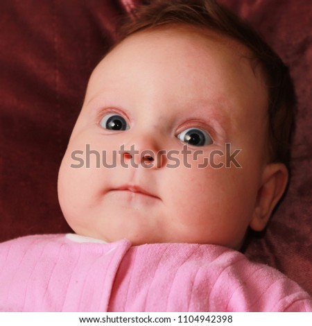 Little baby girl with funny surprise expression on her face