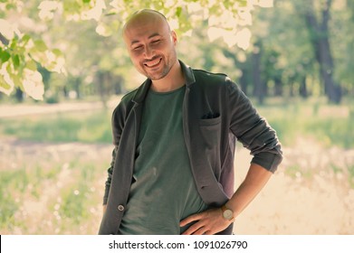 face of a bearded smiling bald man in the park. Portrait of a middle-aged man. - Shutterstock ID 1091026790
