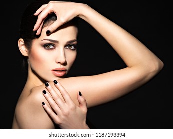 Face Of A Beautiful Girl With Fashion Makeup And Black Nails Posing At Studio Over Dark Background