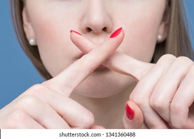 Face Of A Beautiful Woman, Girl Holding Fingers Crossed At Her Lips, Shows Taboo Sign, Close Up