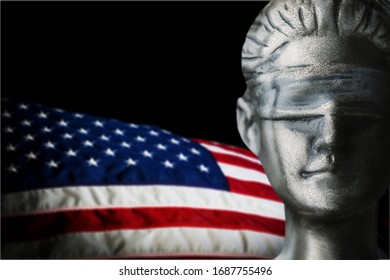 The Face Of Blind Lady Justice And USA Flag On Dark Background