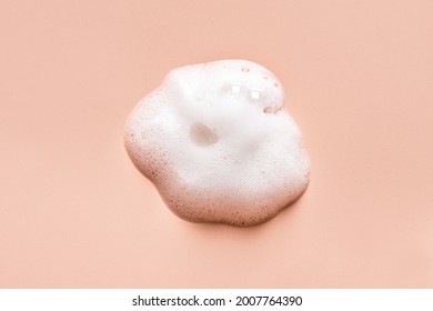 Face Cleansing Mousse Or Bubble Mask Sample. White Cleanser Foam Bubbles On Nude Background. Soap, Shower Gel, Shampoo Foam Texture Closeup.