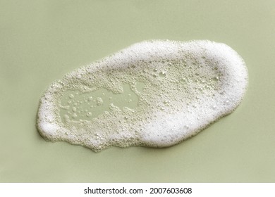 Face cleansing mousse sample. White cleanser foam bubbles on green background. Soap, shower gel, shampoo foam texture closeup. - Shutterstock ID 2007603608