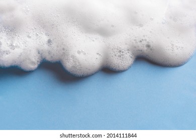 Face Cleansing Mousse Sample. White Cleanser Foam Bubbles On Blue Background, Copy Space. Soap, Shower Gel, Shampoo Foam Texture Closeup.