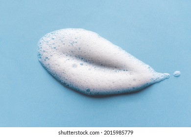 Face cleansing mousse sample. White cleanser foam bubbles on blue background. Soap, shower gel, shampoo foam texture closeup. - Shutterstock ID 2015985779