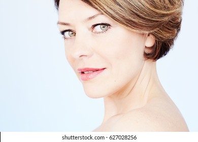 Face Close Up Of Beautiful Middle Aged Woman With Short Brown Hair, Red Lips And Fresh Makeup Over Blue Background - Beauty Concept