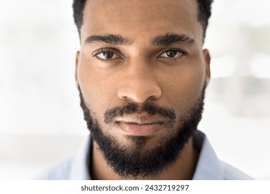 Face close up shot of serious handsome young African man with stylish beard looking at camera. Attractive male model with smooth skin and stubble posing for closeup cropped beauty care portrait - Powered by Shutterstock