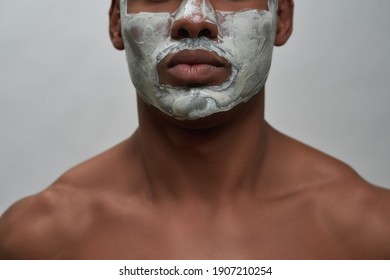 Face closeup of shirtless young african american man using facial blackhead removal mask, posing isolated over gray background. Beauty procedure and skincare routine concept. Horizontal shot
