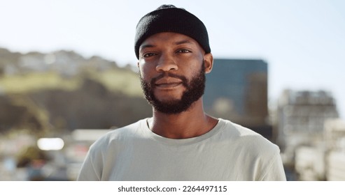 Face, confident and city with an edgy black man outdoor in an urban town for fashion or street style. Portrait, cityscape and lifestyle with a young African American male outside on a summer day