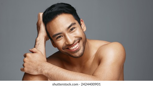 Face, cosmetics and Asian man with skincare, smile and dermatology on a grey studio background. Portrait, Japanese person and happy model with wellness, luxury treatment and beauty with aesthetic - Powered by Shutterstock