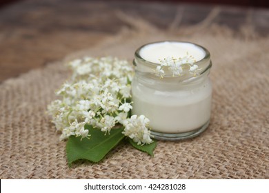 Face cream in a glass jar with chestnut flowers on a background of burlap.Cosmetics. - Shutterstock ID 424281028
