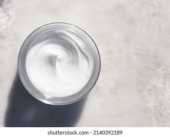 Face cream moisturiser, glass jar on marble stone background, skincare and cosmetic, beauty product concept - Shutterstock ID 2140392189