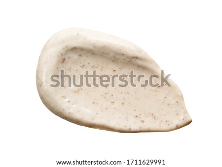 Face cream scrub smear swatch smudge isolated on white. Cosmetic exfoliation product. Beige coffee mask sample close-up