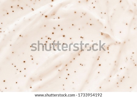 Face cream scrub texture background. Exfoliating skin care product swatch smear smudge. Gentle creamy scrub cleanser sample close up