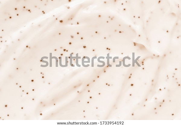 Face cream scrub texture background. Exfoliating skin\
care product swatch smear smudge. Gentle creamy scrub cleanser\
sample close up