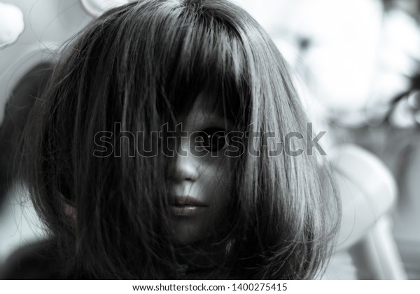 creepy girl with black hair and doll