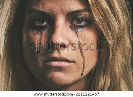 Face, crying and domestic violence with a woman victim of abuse in studio with makeup closeup. Sad, fear and pain with a scared female feeling angry or emotional with grief, tears and problems