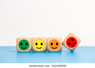 face emotion positive and negative concept. wooden cube with smiley face and sad face icon. satisfaction and service ranking.