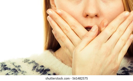 Face expression, human emotions concept. Shocked and surprised young blonde woman covering mouth with her hand.