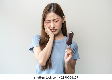 Face Expression Suffering From Sensitive Teeth And Cold, Asian Young Woman, Girl Feeling Hurt, Pain Eating Ice Cream, Lolly. Toothache Molar Tooth At Home, Dental Problem Isolated On White Background.