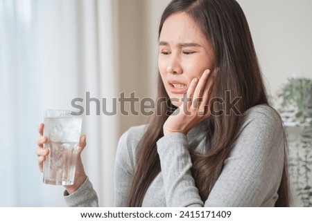 Face expression suffering from sensitive teeth, Asian young woman touching cheek