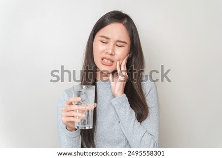 Face expression suffering from sensitive teeth, Asian young woman touching cheek