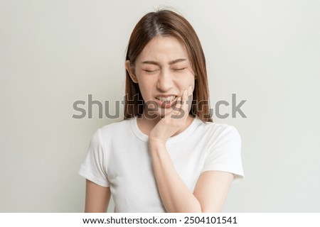 Face expression suffering from sensitive teeth, Asian young woman touching cheek