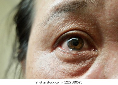 Face and eyes of 40s Asian woman.Her brown eyes filled up with tears.Depression,stress in postmenopausal women or menopause or Middle-aged.Hormonal changes cause her to regret or cry.Selective focus.