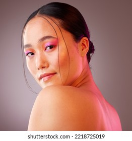 Face, Eyeshadow And Neon Makeup Of Woman On Gray Studio Background. Portrait, Unique Skincare Or Facial Beauty Cosmetics Treatment Of A Beautiful Female, Girl Or Model From Japan With Glowing Skin.