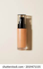 Face Foundation In A Glass Dispenser On A Beige Background. Mockup.