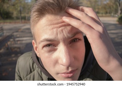 Face of a guy looking into the camera lens close-up outdoors