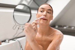Face Hair Removal. Woman Shaving Removing Moustache Above Lips Using New Safety Razor Holding Round Mirror Bathing In Modern Bathroom Indoors. Depilation And Skincare Concept. Selective Focus