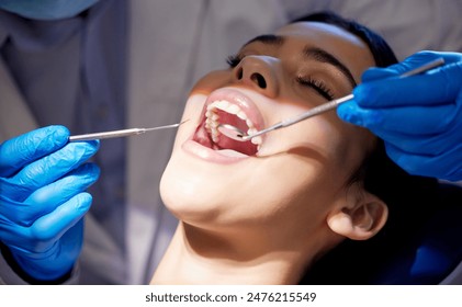 Face, hands and tools with woman at dentist for oral hygiene or dental care appointment closeup. Checkup, healthcare and medical equipment with patient in chair at clinic for mouth cleaning or exam - Powered by Shutterstock