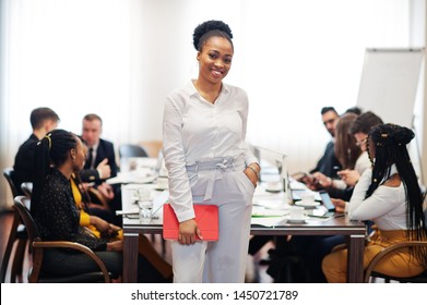 Face Of Handsome African American Business Woman, Holding Tablet On The Background Of Business Peoples Multiracial Team Meeting, Sitting In Office Table.
