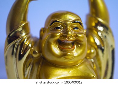 Face of laughing Golden budai hotei is a Chinese folkloric deity. Name means "Cloth Sack", a laughing buddha on the sand Note to the reviewer: Budai, Hotei, Pu-Tai is the right words.